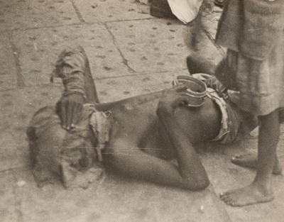 Bombay (beggar on ground, with face covered)