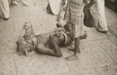 Bombay (beggar on ground, with face covered)
