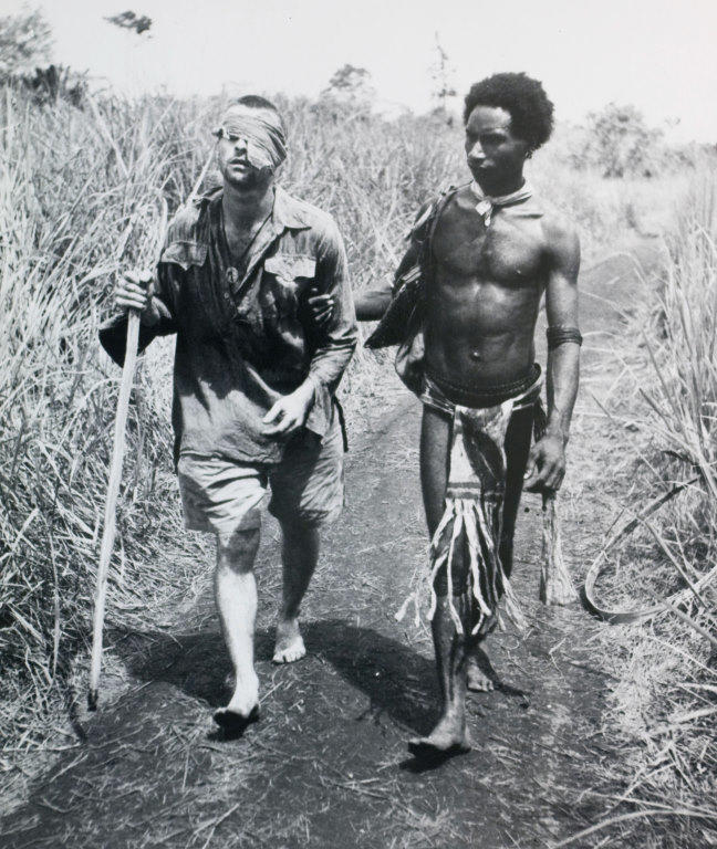 Blinded soldier, Buna, New Guinea - Private George ‘Dick’ Whittington being led to an aid station by Raphael Oimbari 25 December 1942