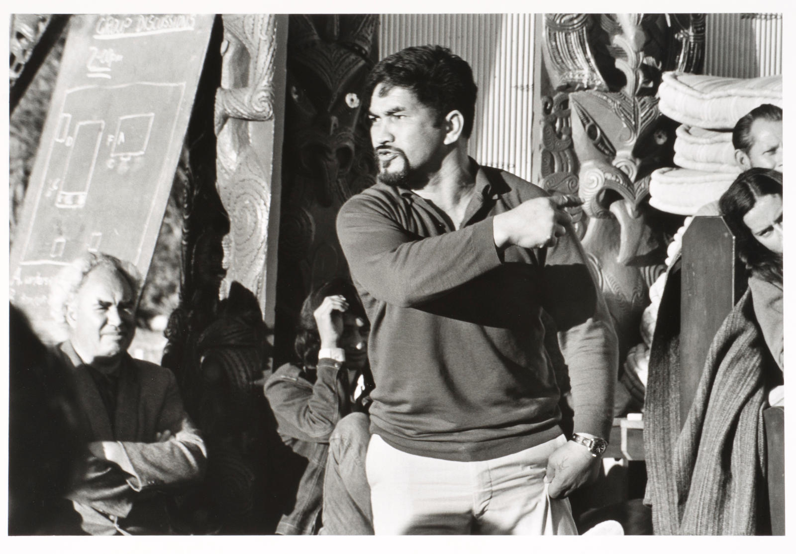 Tukaki wharenui, Te Kaha-nui-a-tiki marae, Te Kaha. Dun Mihaka, Heretaunga Pat Baker, left background. June 1973