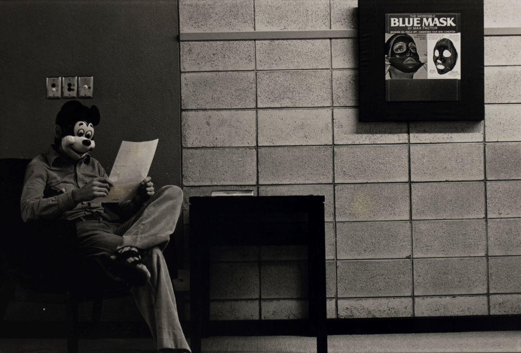 (Man in Mickey mask with Max Factor ad on wall)