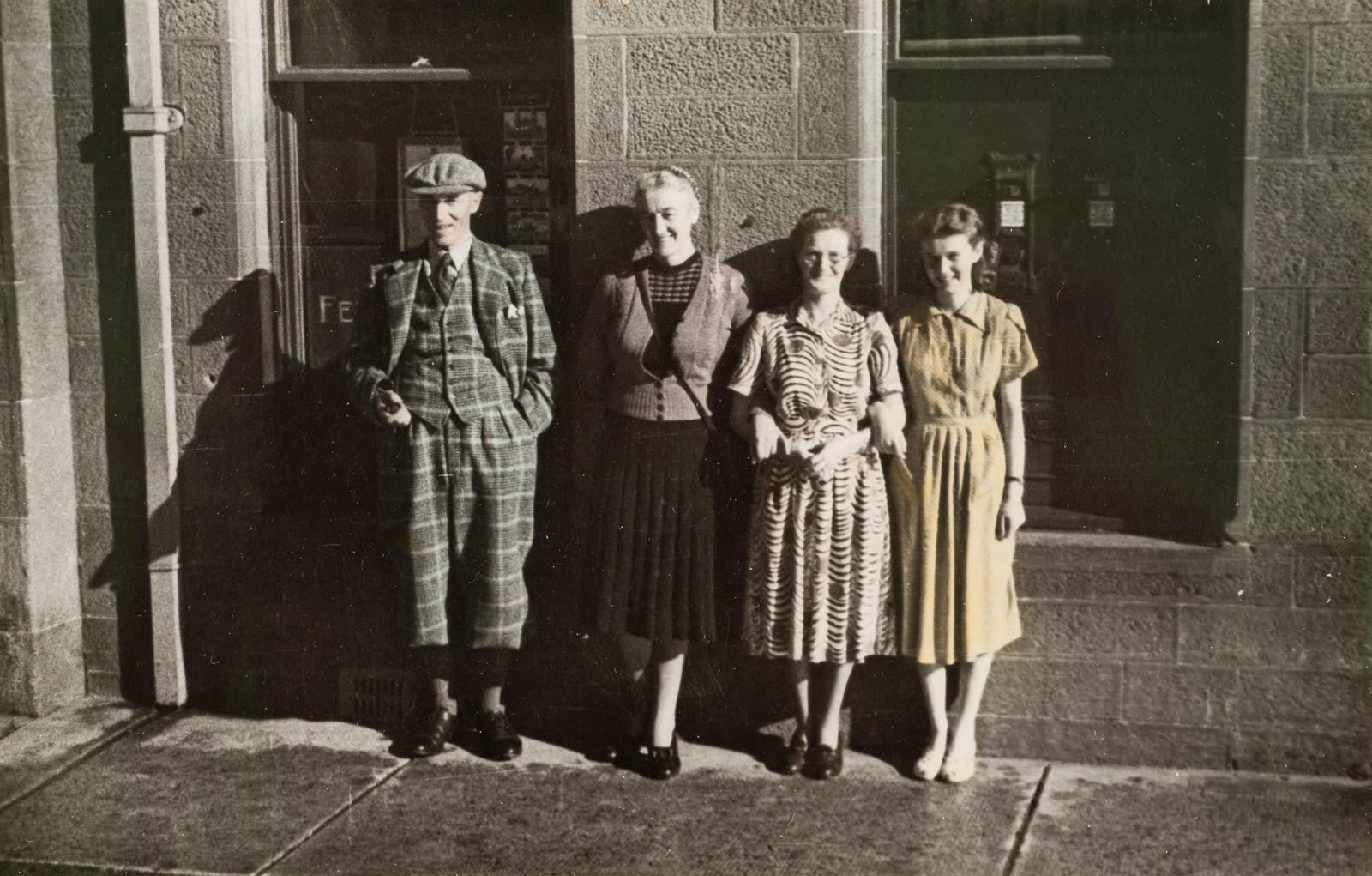 (Mary outside building with man in tweed outfit and two women)