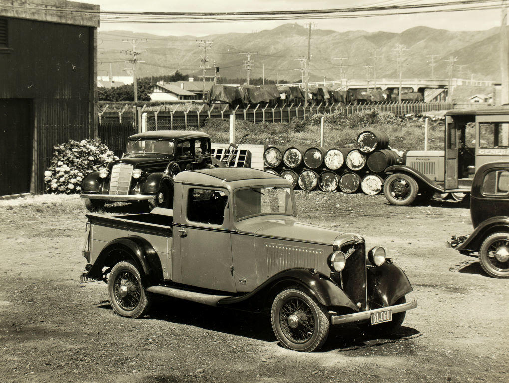 (Cars and truck outside shed - Bedford truck?)