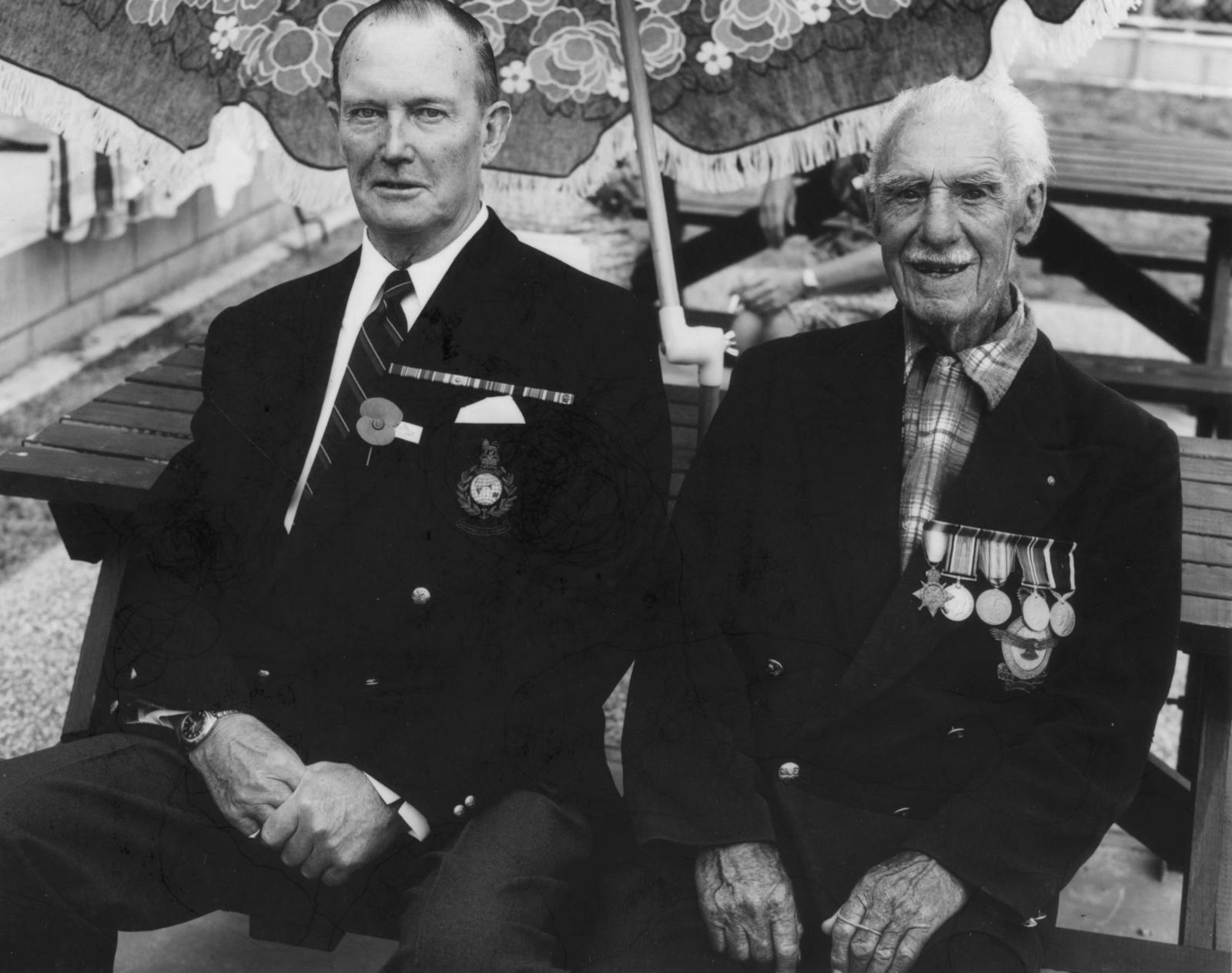 The Hibiscus Coast Project, ANZAC Day Veterans: Two Veterans Sitting With Backs To Barbeque Table
